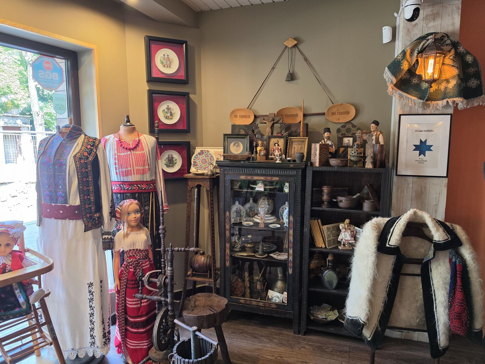 Traditional Romanian folk costumes, hand-painted ceramic plates and antique artifacts on display in the mini-museum at Restaurant Ceaun, Bucharest