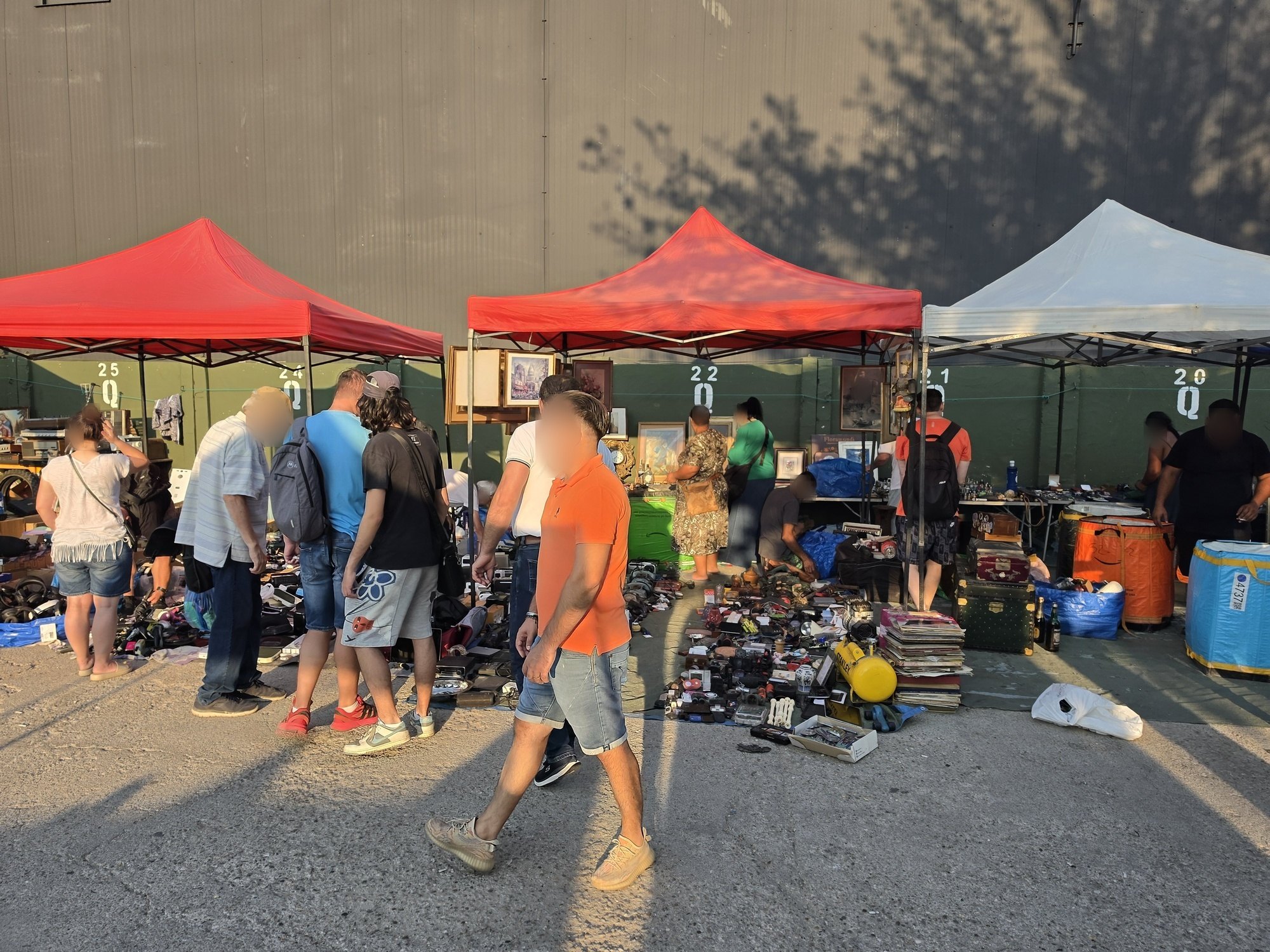 Numbered stall pitches under red and white canopies at the Valea Cascadelor flea market in Bucharest