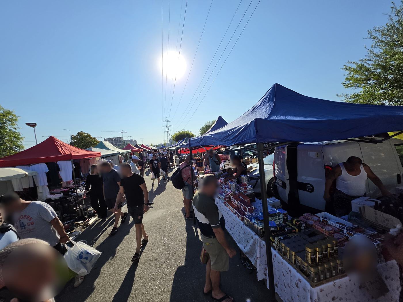 Rows of stalls under coloured canopies at the Valea Cascadelor flea market in Bucharest on a Saturday morning