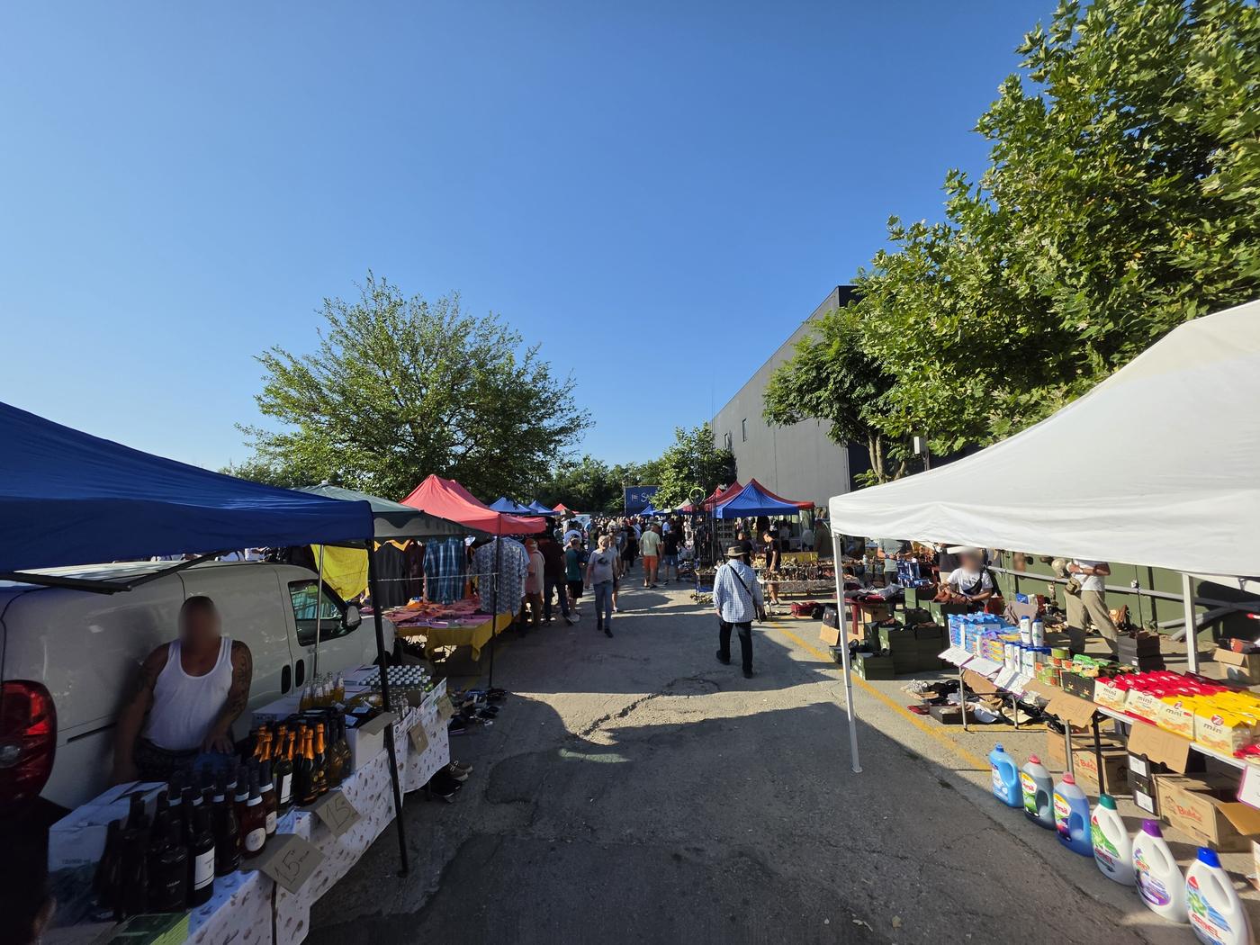 Stalls selling household goods, coffee and packaged products alongside second-hand items at the Bucharest flea market