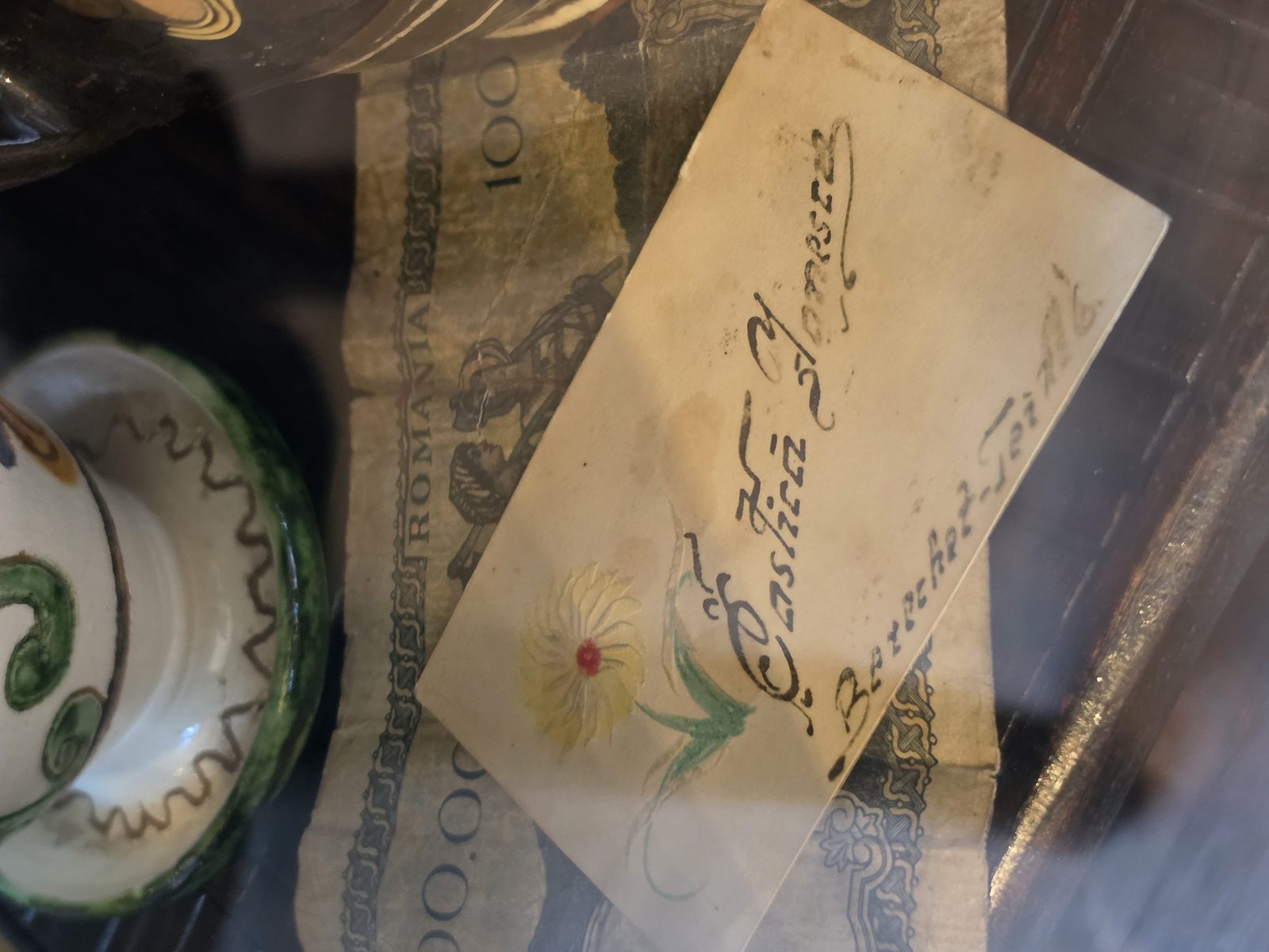 Carte de vizită veche cu floare pictată manual și adresa Berechet-Tei, expusă în muzeul Restaurant Ceaun