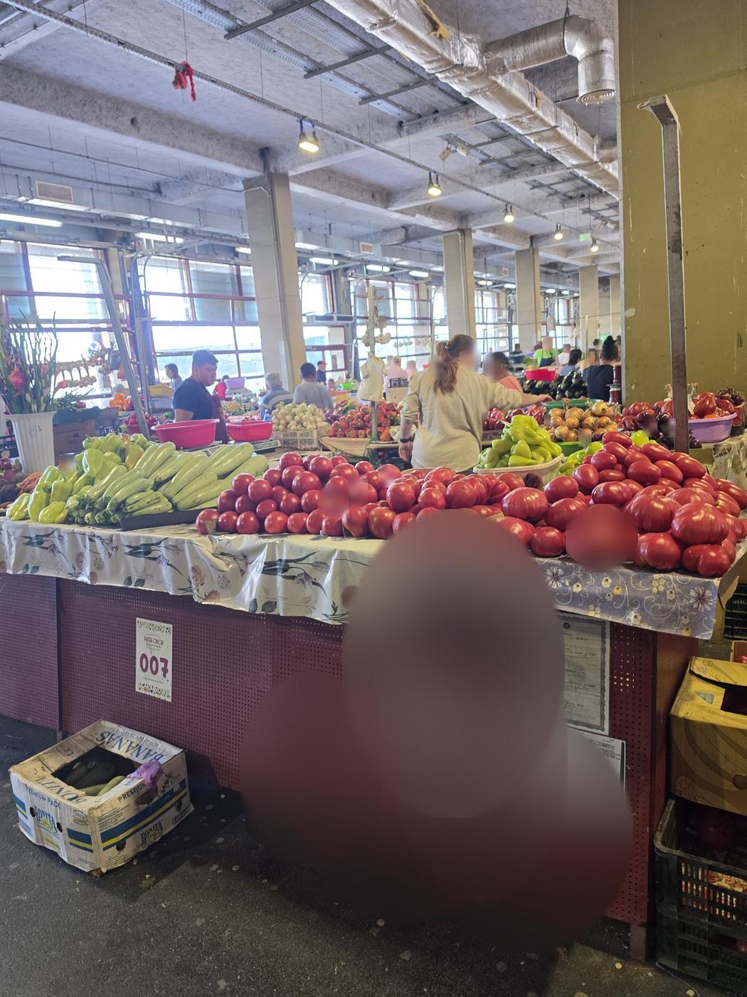 Fresh tomatoes, zucchini and peppers at a produce stall inside Obor Market