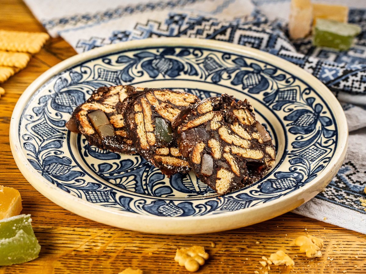 Felii de salam de biscuiți cu rahat, pe o farfurie de ceramică pictată, la Restaurant Ceaun